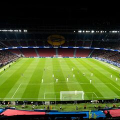 Gece aydınlatılmış stadyumda oynanan futbol maçı
